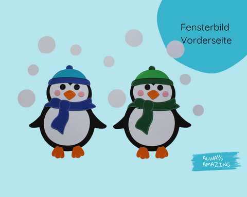 Vorderseite des Pinguin-Fensterbild-Bastelsets mit zwei Pinguinen in blauen und grünen Wintermützen auf hellblauem Hintergrund mit Schneeflocken.